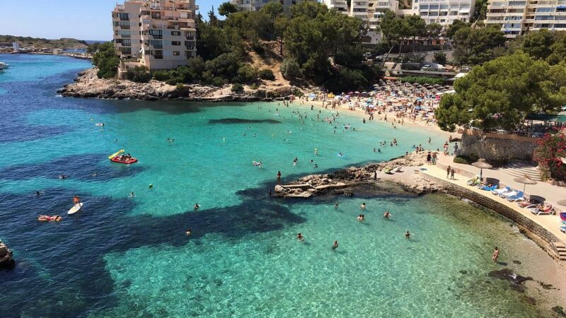 Cala Illetes in Mallorca, showcasing its crystal-clear turquoise waters and inviting sandy beach, perfect for relaxation.