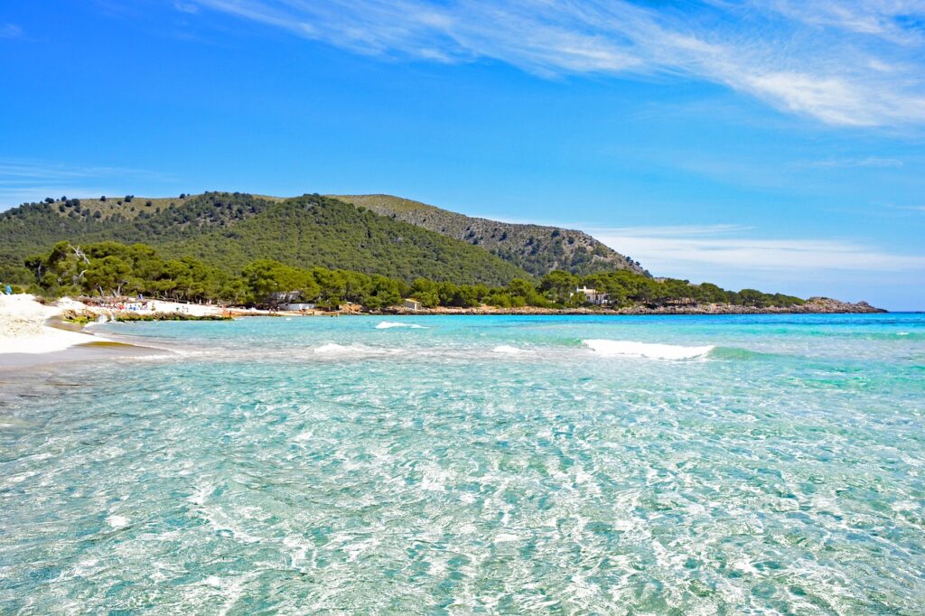 Surrounded by pine forests, Cala Agulla is one of Mallorca’s most scenic beaches, offering pristine waters, soft sand, and a perfect blend of nature and relaxation.