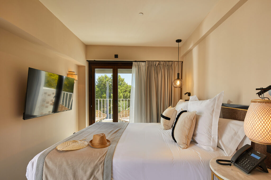 Room with a double bed at Hotel Belle Marivent. Minimalist decor in light tones with a balcony.